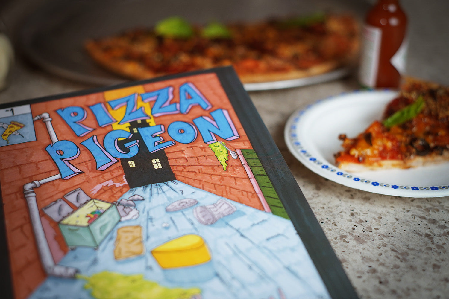 A graphic novel about a pigeon with pizza for wings, pictured in front of a slice of pizza.